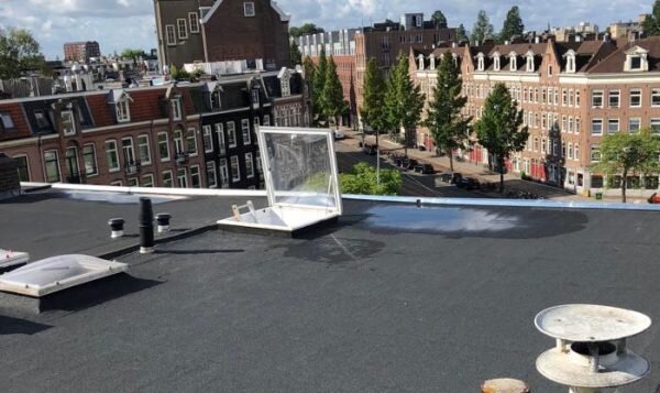 Opgeleverd plat dak met lichtkoepel en ventilatiekap